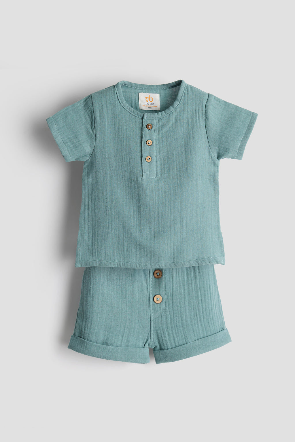 Light blue children's shirt and shorts set on a light gray background