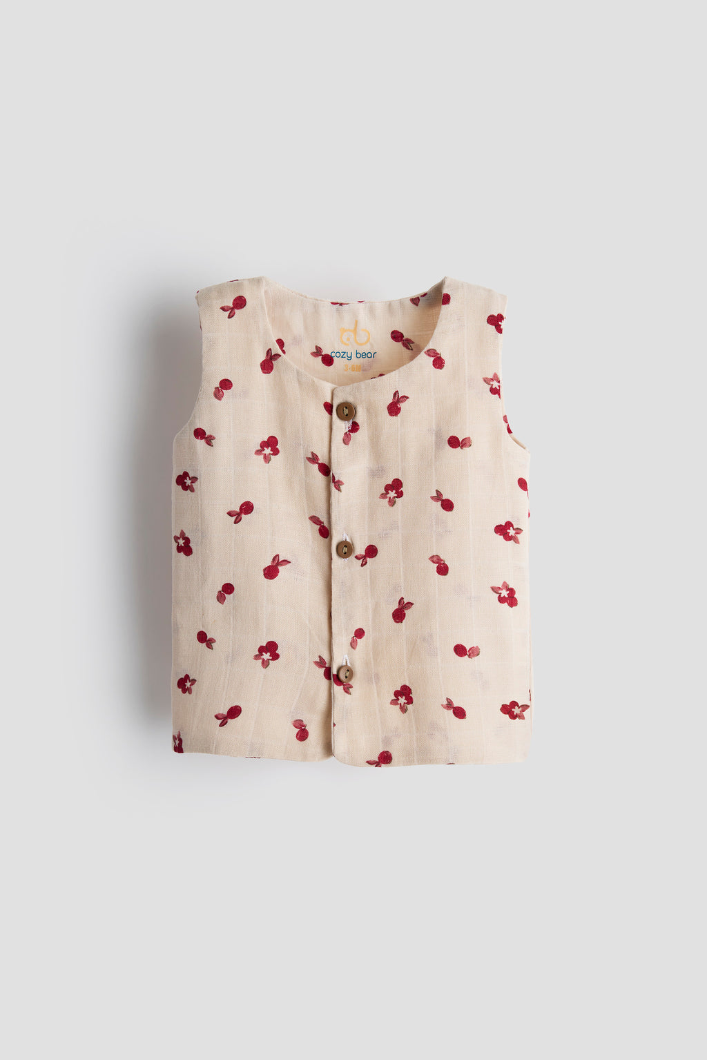 Beige sleeveless top with red floral pattern on a light gray background