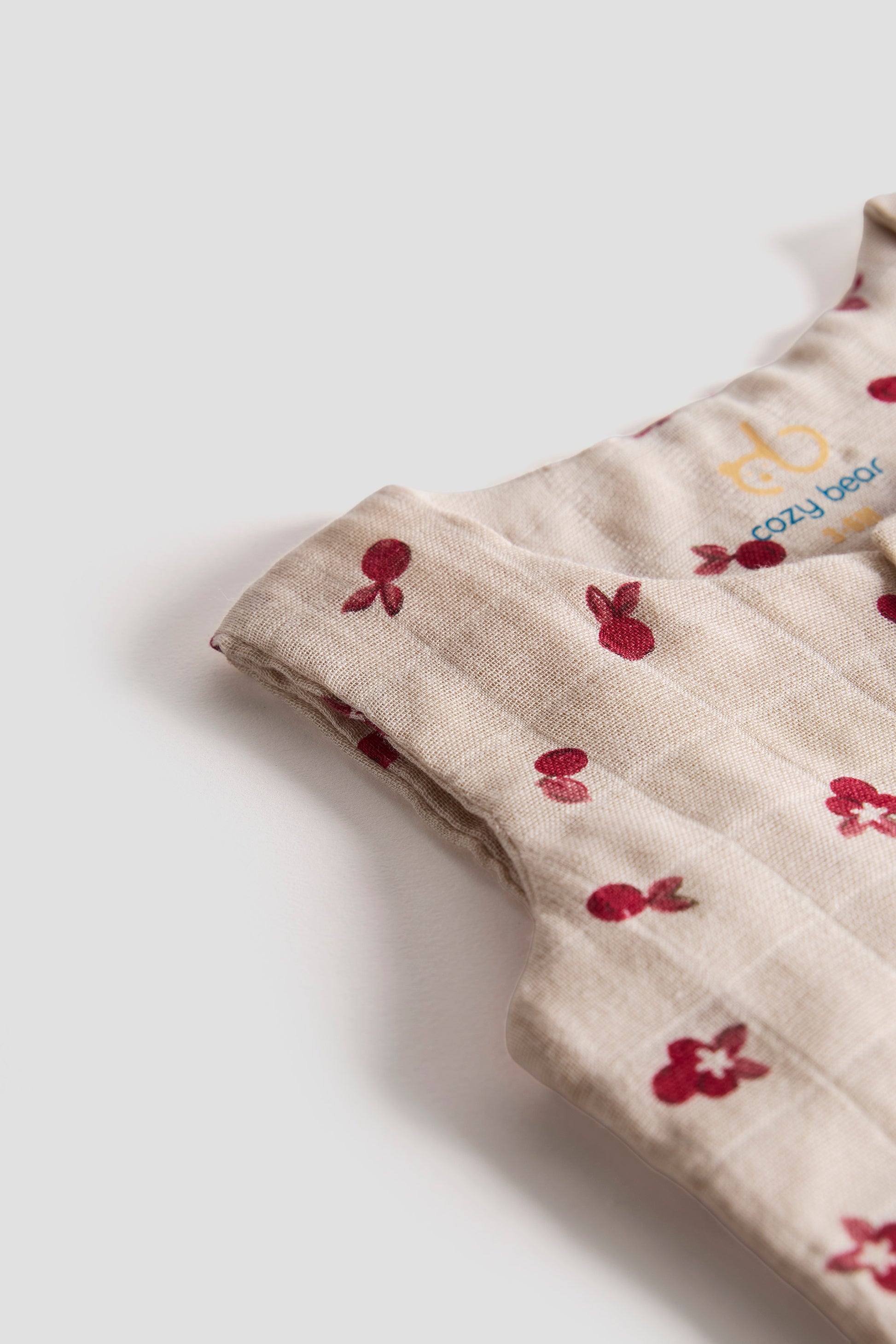 Baby romper with red floral pattern on a light background