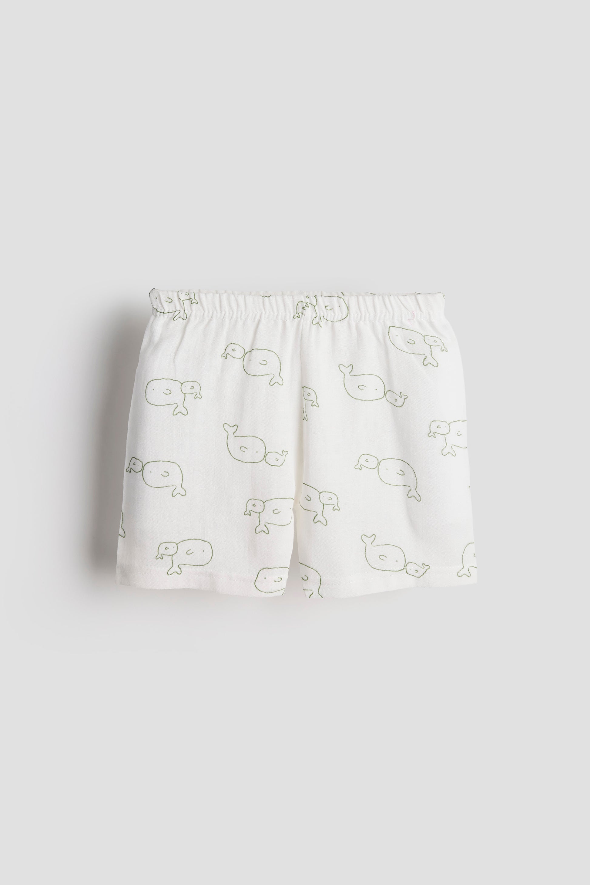 White shorts with whale pattern on a light gray background