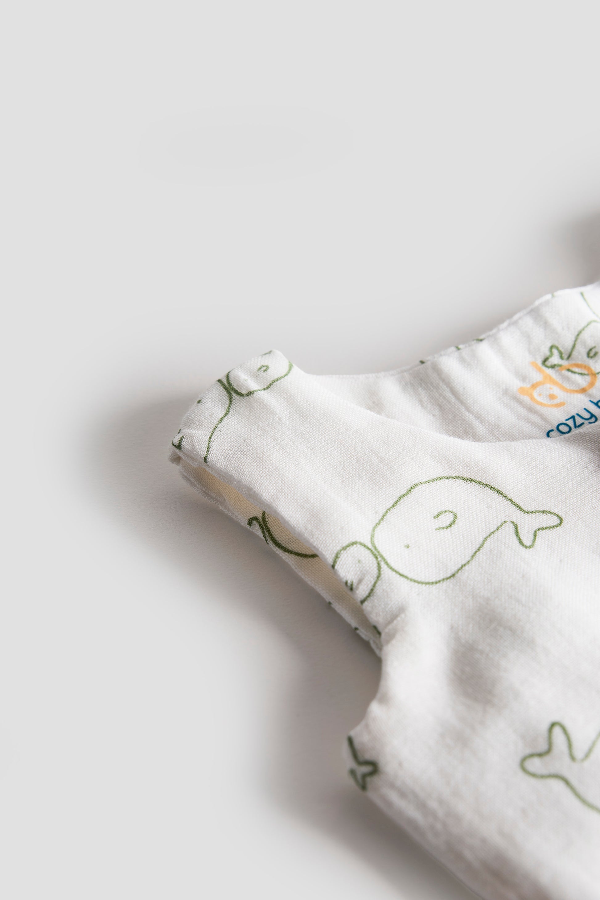 Close-up of a baby garment with whale pattern on a light gray background
